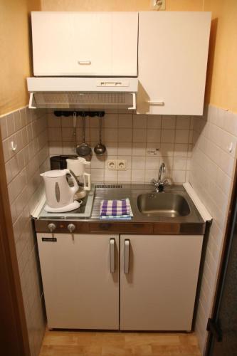 a small kitchen with white cabinets and a sink at Apartment Haus Budinger by Interhome in Alf