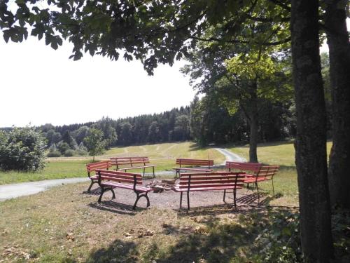 a group of park benches sitting in a park at Apartment Saydaer Höhe by Interhome in Sayda