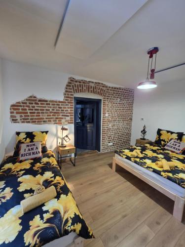 ein Schlafzimmer mit zwei Betten und einer Ziegelwand in der Unterkunft Apartament klimatyczny in Piece