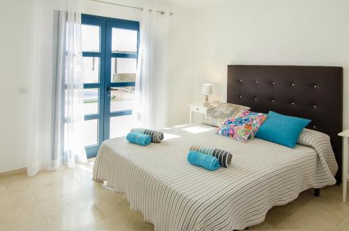 プラヤ・ブランカにあるVilla Valeriaのベッドルーム(青い枕の大型ベッド1台付)
