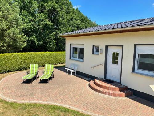 a patio with two green chairs and a building at Holiday Home Klosterwald by Interhome in Dargun