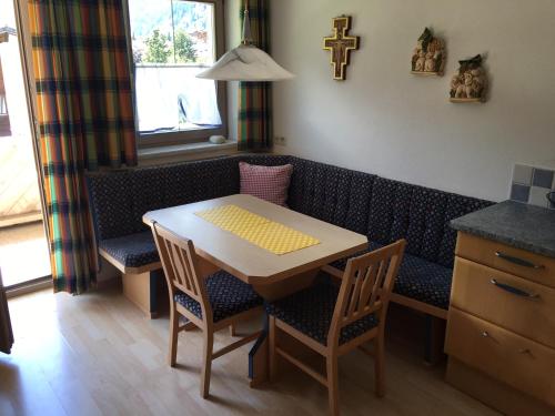 a dining room table and chairs with a cross on the wall at Hotel & Appartements Alpenresidenz Viktoria in Neustift im Stubaital