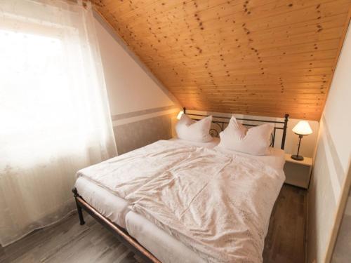 a bed in a room with a wooden ceiling at Apartment Fewo Dirks 2 by Interhome in Hemfurth-Edersee