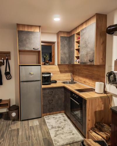 a kitchen with wooden cabinets and a stainless steel refrigerator at Suncani breg in Crni Vrh