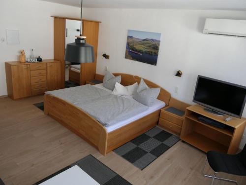 a small bedroom with a bed and a television at Apartment Haus Budinger by Interhome in Alf