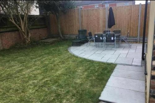 a backyard with chairs and tables and a fence at Spacious and Comfortable - 5 Bedroom Home in Kettering
