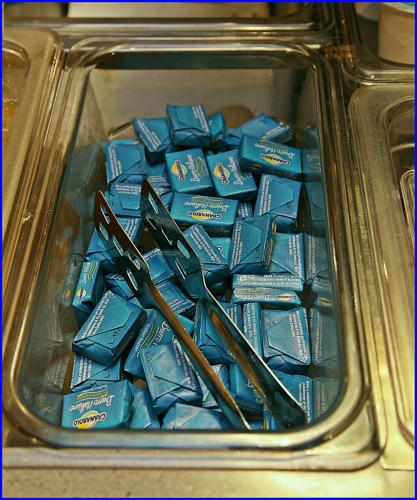 a metal container filled with blue fudge and tongs at Hotel Meeting in Ciampino