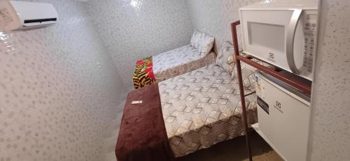 a small room with a bunk bed and a tv at "Taberna dos Castilho" in Bertioga