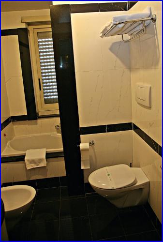 a bathroom with a toilet and a sink and a tub at Hotel Meeting in Ciampino