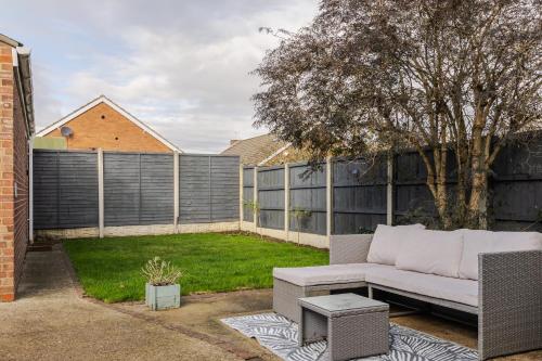 a backyard with a couch and a fence at Danby House Messingham nr Elsham, Brigg, Immingham, Skunthorpe, Gainsborough - We welcome Family & Contractor Stays in Messingham