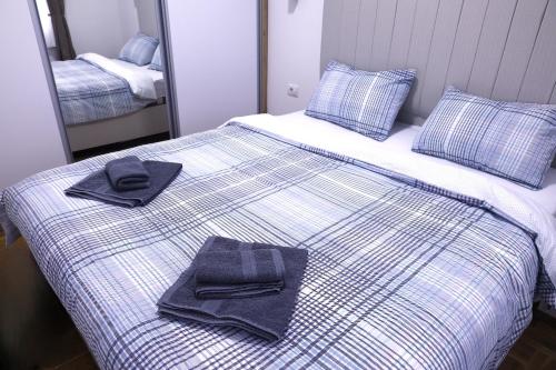 een bed met twee handdoeken bovenop bij Splendid J&R apartman in Bijeljina