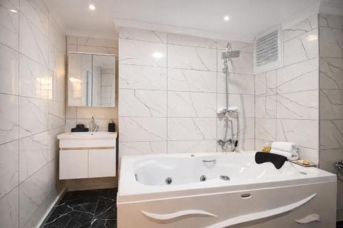 a white bathroom with a tub and a sink at Valentina Apart Hotel in Istanbul