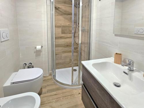 een badkamer met een douche, een toilet en een wastafel bij Moda Apartments Scalette in Sestriere