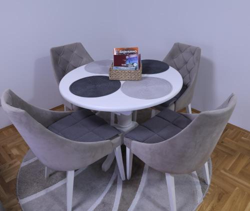 a white table and chairs with a book on top at Splendid J&R apartman in Bijeljina