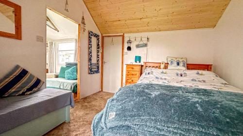 a bedroom with a large bed and a wooden ceiling at Oceans End in Bacton
