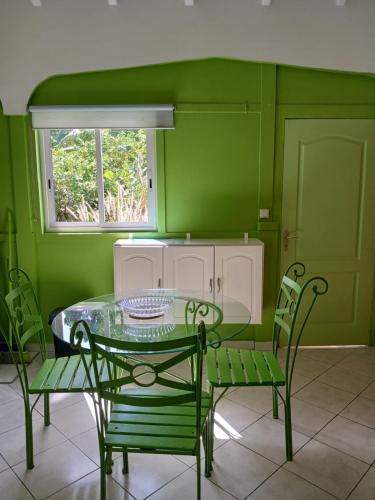 大博格Résidence rose Cannelle的绿色的用餐室配有玻璃桌和椅子