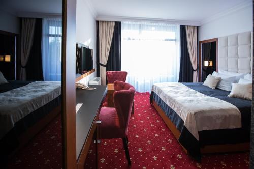 MorančaniにあるHotel Exclusive Presidentのベッド2台と机があるホテルの部屋