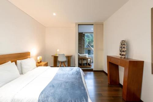 a bedroom with a bed and a desk with a chair at Apartamentos Casa Grande in Rionegro