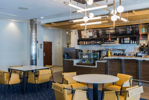 维斯坦顿城西安普敦霍利万怡酒店的一间带2张桌子和椅子的餐厅和一间酒吧