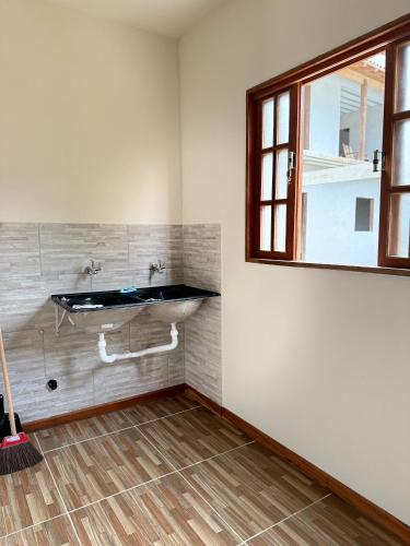 a bathroom with a sink and a window at Paraty Prime House in Paraty