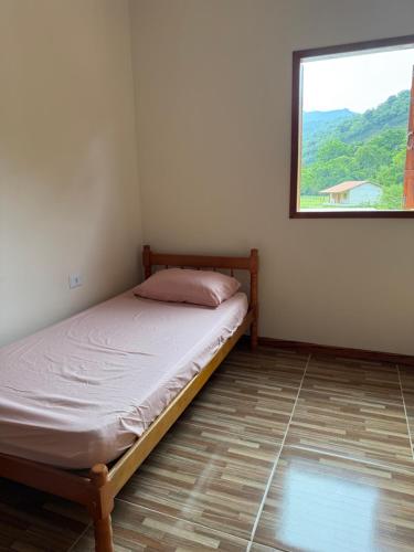 a small bedroom with a bed with a window at Paraty Prime House in Paraty