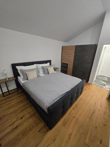 a bedroom with a large bed and a wooden floor at Stylische Ferienwohnung 2 in Salzburg