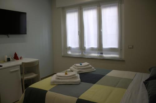 een slaapkamer met een bed met handdoeken erop bij L'Oasi del Poeta in Crotone