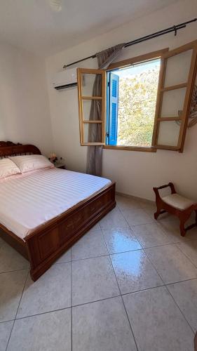 a bedroom with a large bed and a window at Dina's Beach House in Karpathos
