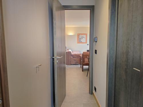 un corridoio con porta che conduce a un soggiorno di Moda Apartments Cimaboschi a Sestriere