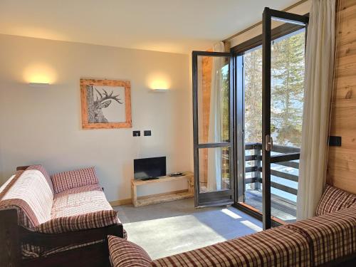 a living room with two couches and a television at Moda Apartments Cimaboschi in Sestriere