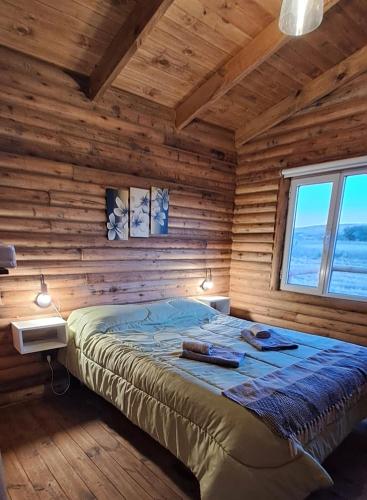 a bedroom with a bed in a log cabin at Cabaña A&A in Sierra de la Ventana