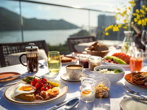 une table avec des assiettes de nourriture et de boissons dessus dans l'établissement The Silveri Hotel Hong Kong - MGallery Collection, à Hong Kong