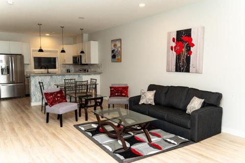 ein Wohnzimmer mit Couch und Tisch und eine Küche in der Unterkunft Havilah's Place Regina in Regina