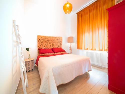 una camera da letto con un letto bianco con cuscini rossi di Festina Lente B&B a Porto Recanati
