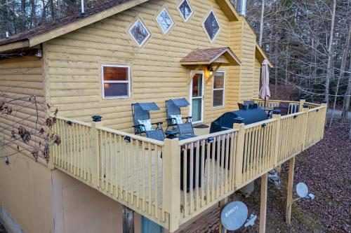 a cabin with a deck with chairs on it at Mountain Cabin Fireplace Views Fire Pit in Sautee Nacoochee