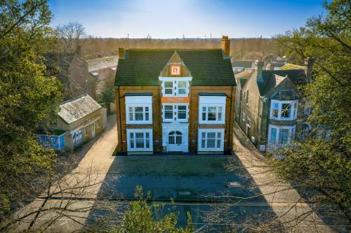 a large house with white windows in a city at Thorpe Lodge Hotel in Peterborough