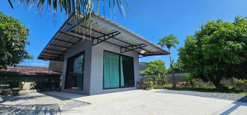 a house with a large window on the side of it at ST house in Ban Nua Khlong