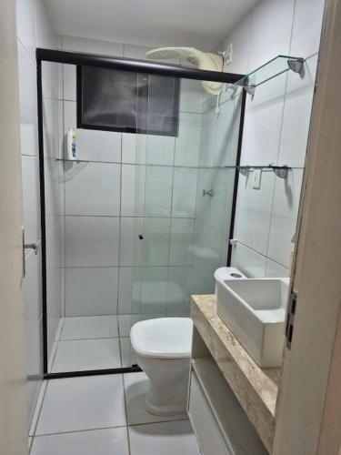 een badkamer met een douche, een toilet en een wastafel bij Apartamento com suite in Parnamirim