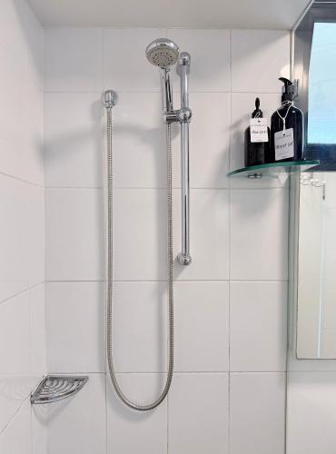 a shower with a shower head in a bathroom at Potts Point Cozy Studio Near Parks Water in Sydney