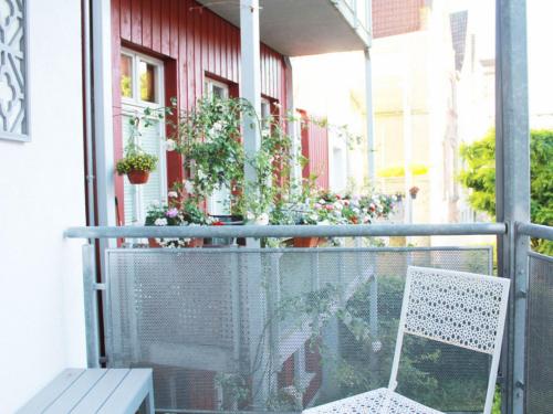 een witte stoel op een balkon met planten bij Ferienloft am Marktplatz - ABC609 in Wismar