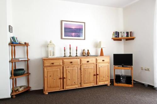 ein Zimmer mit einem Holzschrank mit drei Kerzen darauf in der Unterkunft Silbermöwe in Hörnum