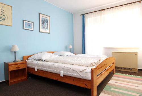 Schlafzimmer mit einem Bett mit einem Holzrahmen und einem Fenster in der Unterkunft Silbermöwe in Hörnum