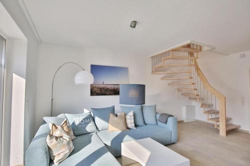 a living room with a blue couch and a staircase at City Marina, CM24b in Cuxhaven
