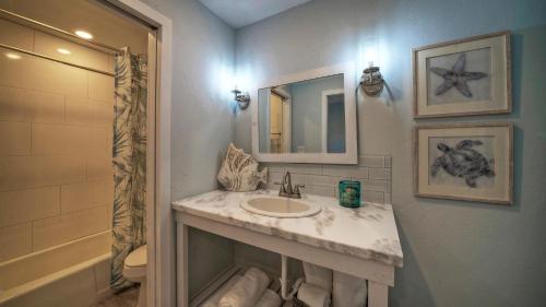 ein Badezimmer mit Waschbecken, Spiegel und Dusche in der Unterkunft 2 Units Beach Boardwalk Pool Pickleball Tennis Island Retreat Complex in Port Aransas