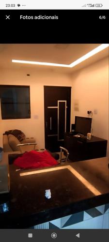 a living room with a couch and a desk with a computer at Casa de Praia Beta Simão in Praia Grande