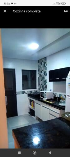 a kitchen with a stove and a counter top at Casa de Praia Beta Simão in Praia Grande