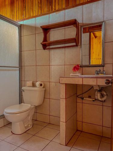 a bathroom with a toilet and a sink at Hotel El Atardecer in Monteverde Costa Rica