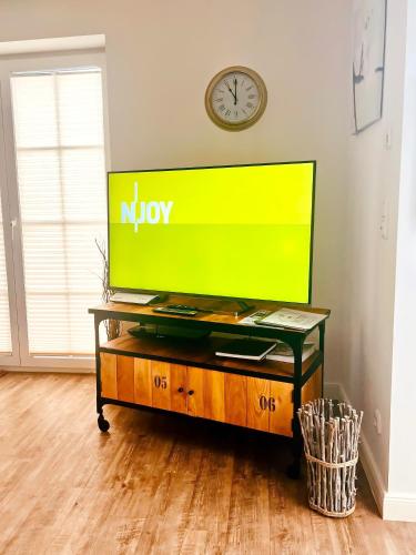 a tv on a table in a room with a clock at Haus Clara in Hörnum