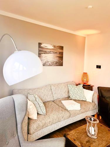 a living room with a couch and a table at Haus Clara in Hörnum