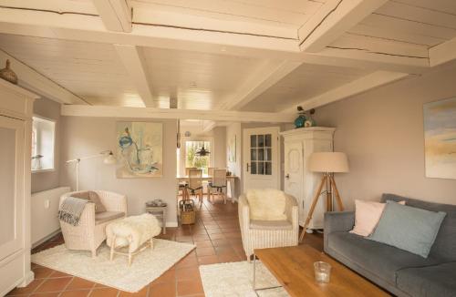 a living room with a couch and chairs at Foftein in Borgsum